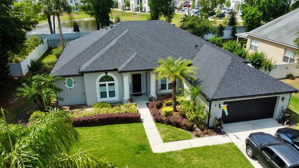 Drone view of a suburban Florida home with clean asphalt shingle roof