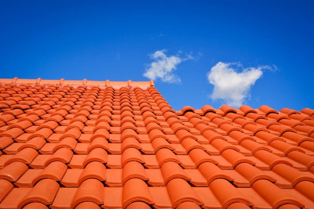 Close-up of a clean orange barrel tile roof against clear blue sky